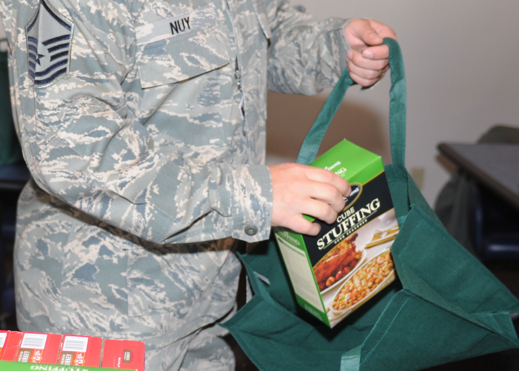 U.S. Air Force Master Sgt. Jason Nuy, 27th Special Operations Wing remote operations center superintendent, loads stuffing into a Thanksgiving basket at the Pecos Trail Dining Facility Nov. 13, 2013, at Cannon Air Force Base, N.M. More than 300 baskets were constructed and will be distributed by the first sergeants to Airmen in need this Thanksgiving season. (U.S. Air Force photo/Senior Airman Ericka Engblom)