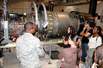Tech. Sgt. Tegarth Bishop a jet engine mechanic assigned to the 482nd Maintenance Squadron discusses the finer details of a General Electric F110-GE-100/129 engine. Twenty four youth from the Little Havana and Homestead Career Centers were treated to a base visit on Nov. 15. (U.S. Air Force photo/Tim Norton)