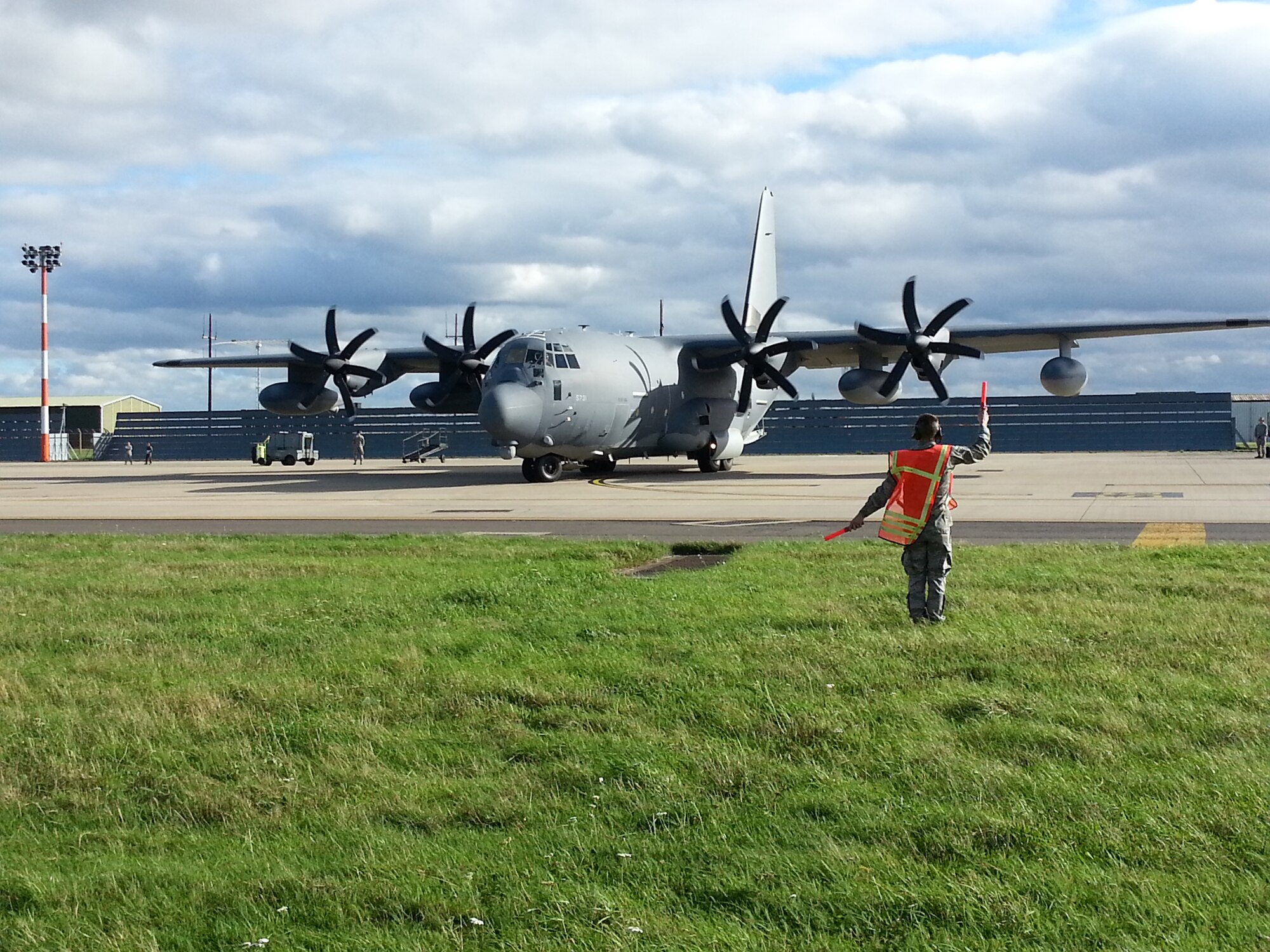 U.S. Air Force Airman 1st Class Sebastian Schmidt, 352nd Special Operations Maintenance Squadron MC-130J Commando II crew chief, marshals an MC-130J Commando II at RAF Mildenhall, England, Oct. 26, 2013. As a precautionary for adverse weather MC-130s from the 352nd Special Operations Group were temporarily relocated Oct. 26, 2013, to a location in Europe. The remaining 352nd SOG aircraft were placed in hagars during the passing storm. Schmidt hails from Wichita Falls, Texas. (U.S. Air Force photo by Chief Master Sgt. William Markham/Released)