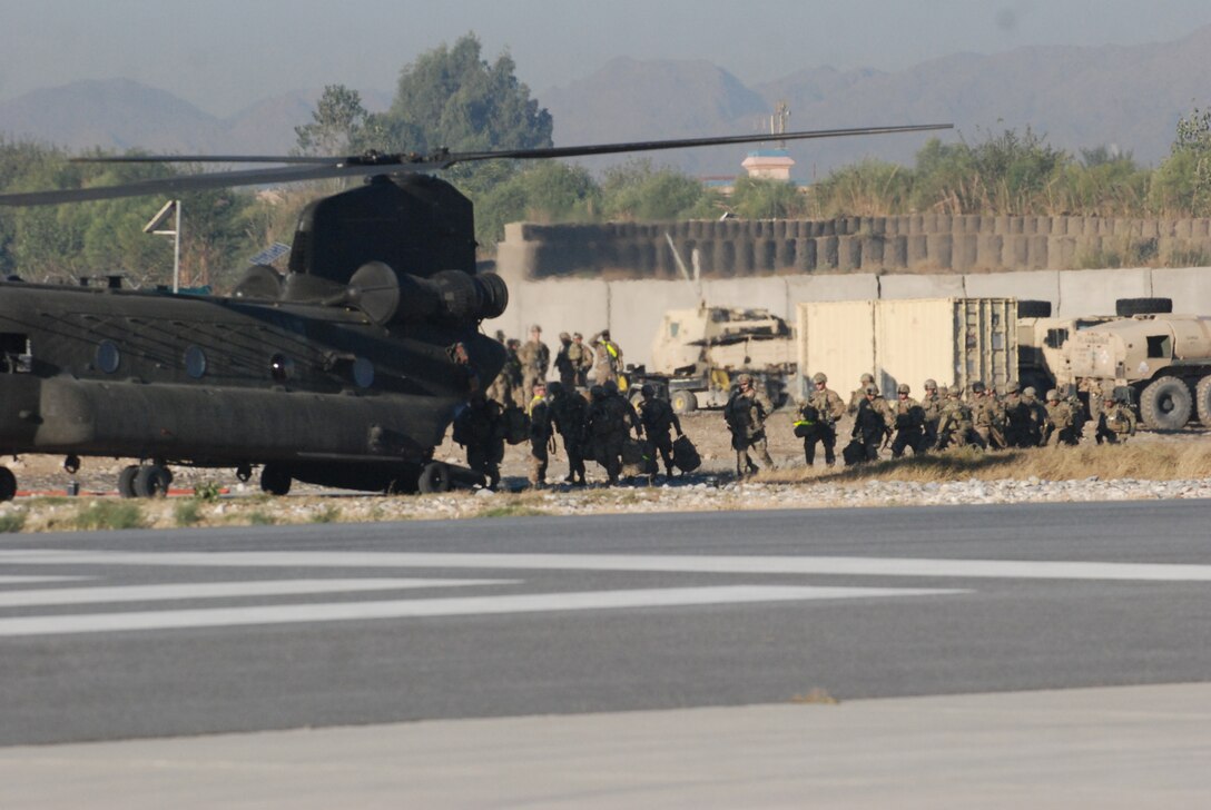 Soldiers hot load a CH-47 Chinook helicopter on Forward Operating Base Fenty, Afghanistan, Nov. 12, 2013. The aircrew, assigned to 3rd Battalion, 10th Combat Aviation Brigade, conducted a mission to move personnel and cargo over eastern Afghanistan.