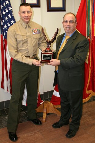 Col. Michael Manning, Marine Corps Systems Command's program manager for Infantry Weapons Systems, congratulates Salvatore Fanelli on winning the Donald Roebling Award, which honors an acquisition civilian. He worked on the acquisition, fielding and support of Mk318 Mod 0 and M855A1 ammunition to the warfighter. 