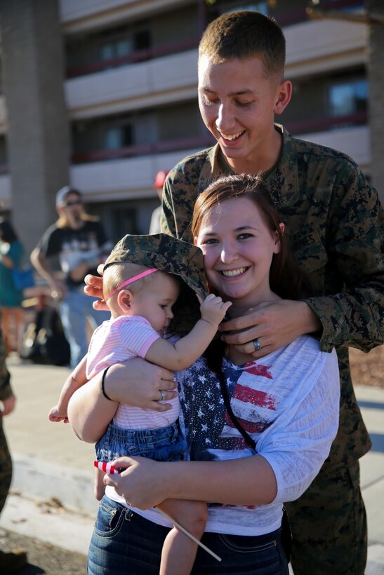 Lance Cpl. Kevin Versluis, amphibious assault vehicle crewman, Bravo Company, 3rd Assault Amphibian Battalion, plays with his daughter, Adalynn, and his wife, Heather, at the company’s homecoming here, Nov. 14, 2013. The Marines returned after being away for six months to Okinawa, Japan, as part of the Unit Deployment Program. The company conducted a variety of training including an officer exchange program with the Japanese military. This allowed Marines to interact with and teach Japanese officers about the Marine Corps’ capabilities.