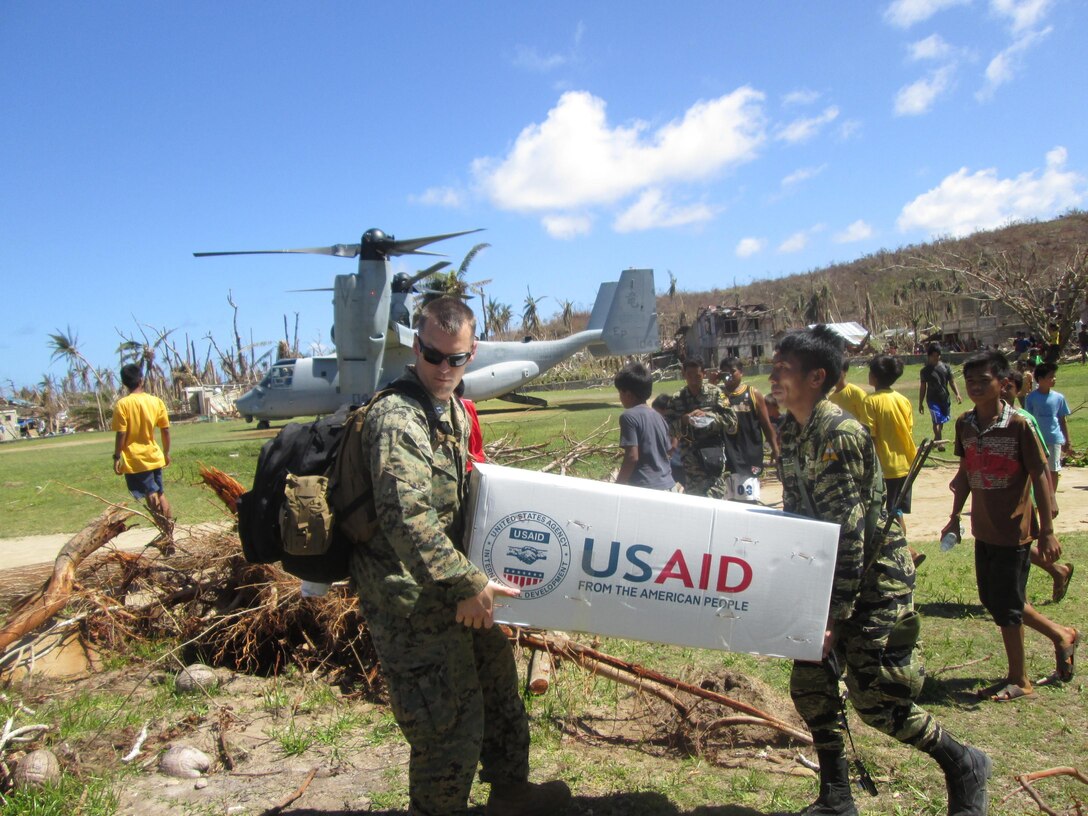 U.S. Marine Capt. Joseph White, left, of Barstow, Calif., the deputy logistics officer of the 31st Marine Expeditionary Unit and Philippine Army PFC Vic D. Victorlano carry U.S. Agency for International Development relief supplies from an MV-22 Osprey tiltrotor aircraft, Nov. 18. A bilateral assessment team landed to deliver relief and determine needs in remote areas in and near Leyte to assess the needs of people isolated by Typhoon Haiyan. U.S. military assets have delivered relief supplies provided by the U.S. Agency for International Development since the start of Operation Damayan, in support of the Government of the Philippines in the wake of Typhoon Haiyan.