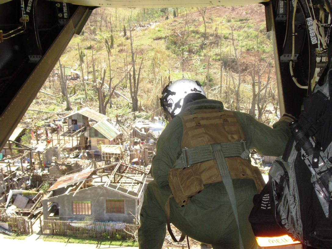 U.S. Marine Cpl. Stephen Jarrell, of Toledo, Ohio, a crew chief with Marine Medium Tiltrotor Squadron 265, observes a destroyed village from a MV-22B Osprey aircraft as a bilateral assessment team lands to deliver relief and determine needs, Nov. 18. The team traveled to remote areas in and near Leyte using an MV-22B tiltrotor Osprey aircraft to assess the needs of people isolated by Typhoon Haiyan. U.S. military assets have delivered relief supplies provided by the U.S. Agency for International Development since the start of Operation Damayan, in support of the Government of the Philippines in the wake of Typhoon Haiyan.