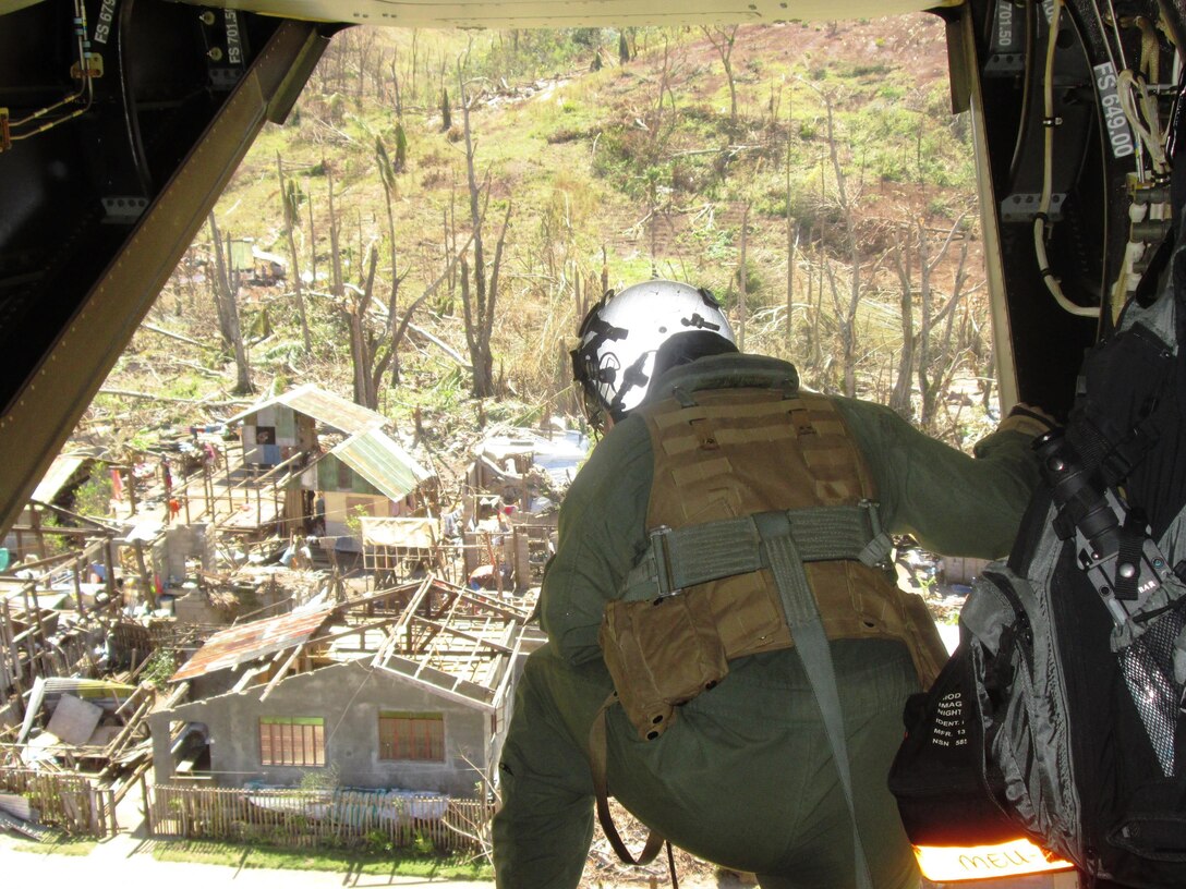 U.S. Marine Cpl. Stephen Jarrell, of Toledo, Ohio, a crew chief with Marine Medium Tiltrotor Squadron 265, observes a destroyed village from a MV-22B Osprey aircraft as a bilateral assessment team lands to deliver relief and determine needs, Nov. 18. The team traveled to remote areas in and near Leyte using an MV-22B tiltrotor Osprey aircraft to assess the needs of people isolated by Typhoon Haiyan. U.S. military assets have delivered relief supplies provided by the U.S. Agency for International Development since the start of Operation Damayan, in support of the Government of the Philippines in the wake of Typhoon Haiyan.