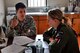 OHAKEA, New Zealand -- United States Air Force Maj. Corey Akiyama goes over drop-zone operational manuals and a certification checklist with Royal New Zealand Air Force Pilot Officer Emma Taylor at a designated drop zone Nov. 14 at the New Zealand Defence Force Raumi Drop Zone near Ohakea, New Zealand. Kiwi Flag personnel are supporting Exercise Southern Katipo -- held on New Zealand’s South Island -- by managing air operations and providing cargo and passenger airlift including tactical air drops to SK participants. SK hosts nine countries involved in air, land and maritime operations. (U.S. Air Force photo by Senior Master Sgt. Denise Johnson)