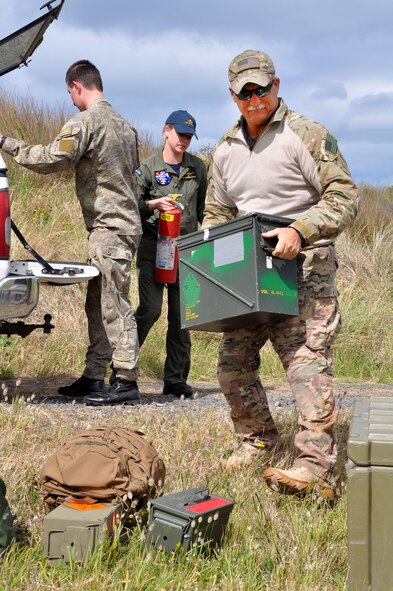 OHAKEA, New Zealand -- (Left to right) New Zealand Army Private Hamish Summers, Royal New Zealand Air Force Pilot Officer Emma Taylor and United States Air Force Chief Master Sgt. Paul Koester unload the drop zone control officer kit for a multilateral air drop subject-matter-expert exchange Nov. 14 at the New Zealand Defence Force Raumi Drop Zone near Ohakea, New Zealand. Taylor is earning her United States drop zone safety officer certification during the multilateral RNZAF-sponsored tactical airlift exercise, Kiwi Flag, comprising air assets from the USAF, RNZAF, Royal Australian Air Force, Republic Of Singapore Armed Forces and French Armed Forces of New Caledonia. New Zealand, Australia, Singapore and United States armed forces personnel contributed to this subject matter exchange comprising more than 20 of the multinationals participating in Exercise Kiwi Flag. Summers is from 51st Aerial Delivery Platoon, 5th Movements Company, 2nd Combat Services Support Battalion out of Linton Military Camp in Palmerston North, New Zealand. Taylor, an air warfare officer, is assigned to 40 Squadron, RNZAF Base Ohakea. Koester is deployed as the 517th Expeditionary Airlift Squadron jumpmaster. He is the pararescue functional manager at home station, Pacific Air Forces Headquarters at Joint Base Pearl Harbor-Hickam, Hawaii. He hails from Colorado Springs, Colo. Kiwi Flag personnel are supporting Exercise Southern Katipo -- held on New Zealand’s South Island -- by managing air operations and providing cargo and passenger airlift including tactical air drops to SK participants. SK hosts nine countries involved in air, land and maritime operations. (U.S. Air Force photo by Senior Master Sgt. Denise Johnson)
