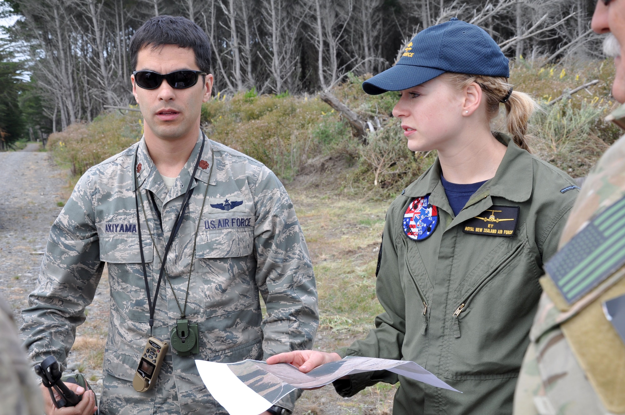 OHAKEA, New Zealand -- United States Air Force Maj. Corey Akiyama clarifies an approach plan with Royal New Zealand Air Force Pilot Officer Emma Taylor and several other multinational partners enroute to a designated drop zone for a multilateral air drop subject-matter-expert exchange Nov. 14 at the New Zealand Defence Force Raumi Drop Zone near Ohakea, New Zealand. Akiyama is certifying Taylor as a U.S.  drop zone safety officer during the multilateral RNZAF-sponsored tactical airlift exercise, Kiwi Flag, comprising air assets from the USAF, RNZAF, Royal Australian Air Force, Republic Of Singapore Armed Forces and French Armed Forces of New Caledonia. Taylor’s certification will enhance interoperability and unified responses when New Zealand and the United States both respond to a combined effort. Taylor, an air warfare officer, is assigned to 40 Squadron, RNZAF Base Ohakea. Akiyama is deployed as the 517th Expeditionary Airlift Squadron drop zone safety officer. He is the air mobility liaison officer for the 615th Contingency Operations Support Group at home station, Camp Henry, Korea. He hails from University Place, Wash. Kiwi Flag personnel are supporting Exercise Southern Katipo -- held on New Zealand’s South Island -- by managing air operations and providing cargo and passenger airlift including tactical air drops to SK participants. SK hosts nine countries involved in air, land and maritime operations. (U.S. Air Force photo by Senior Master Sgt. Denise Johnson)