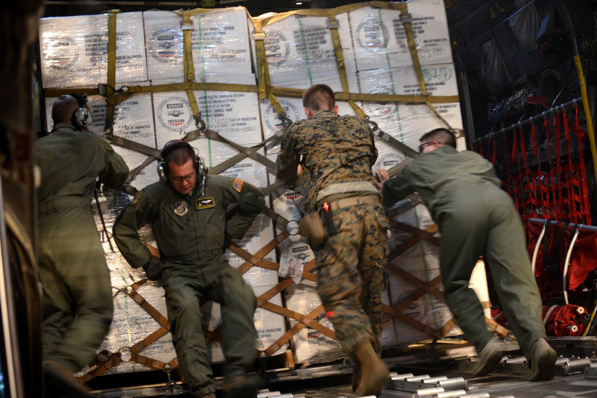 Airmen and Marines load humanitarian aid onto a C-130H aircraft during Operation Damayan at Clark Air Base, Republic of the Philippines, Nov. 18, 2013. Operation Damayan is a humanitarian aid and disaster relief operation supported by a multinational response force. (U.S. Air Force photo by 2nd Lt. Jake Bailey/Released)