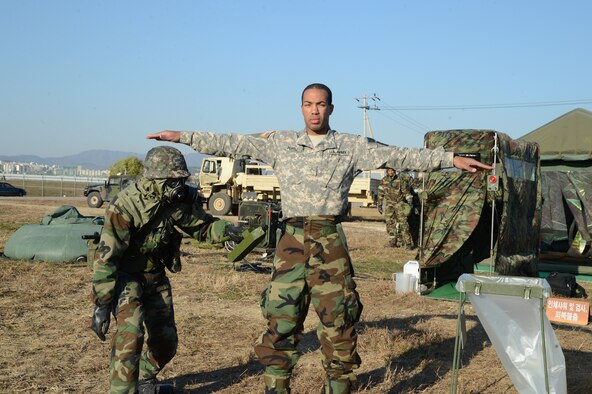SUWON AIR BASE, Republic of Korea - Pvt. Anthony Powell, a chemical specialist with Headquarters and Headquarters Battery, 6th Battalion, 52nd Air Defense Artillery Regiment, is checked for chemical contamination by an Airman with the ROKAF 10th Fighter Wing during a base defense exercise here, Nov. 12.  (U.S. Army Photo by Sgt. Song Sung Geun, Civil Affairs, 6-52nd ADA)