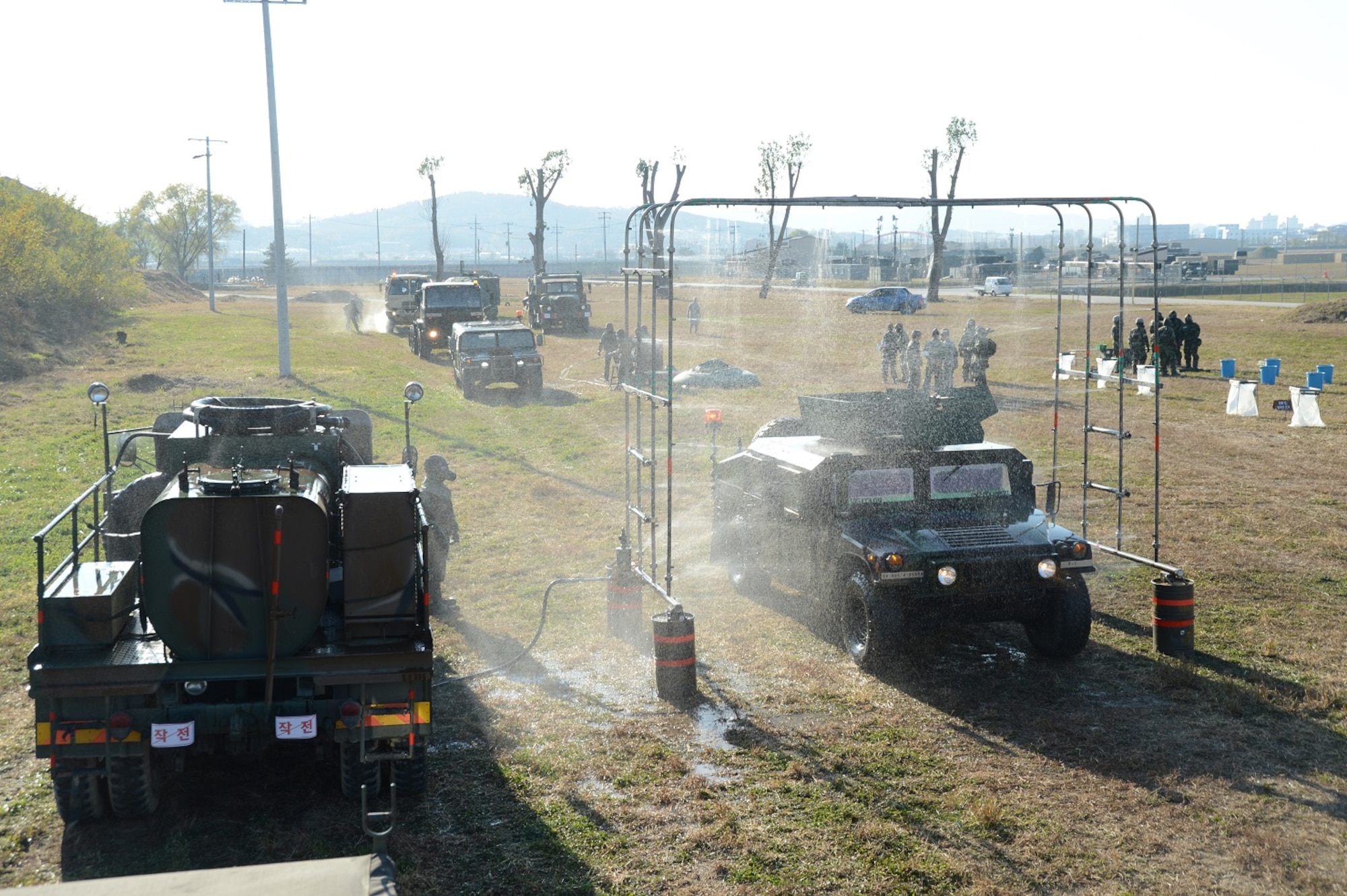 SUWON AB – ROKAF 10th Fighter Wing chemical specialists practice decontaminating the vehicles of Company F, 6th Battalion 52nd Air Defense Artillery Regiment, during a base defense exercise here, Nov. 12. (U.S. Army Photo by Sgt. Song, Sung Geun, Civil Affairs, 6-52 ADA)