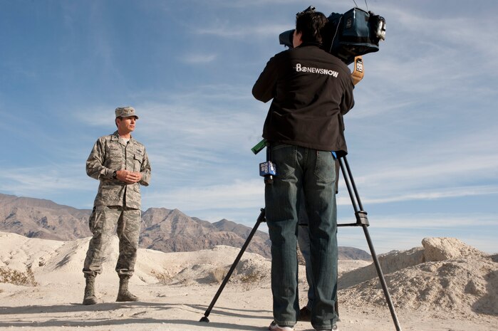 Col. Barry Cornish, 99th Air Base Wing commander, engages in an on-camera interview with local news media during a tour of Tule Springs fossil beds in Las Vegas Nov. 18, 2013. Cornish and other 99th ABW leaders visited the site to show support for a bill that would give Tule Springs the official title of national monument; ensuring a safe air-corridor for Nellis aircraft and preserving the land for educational purposes. (U.S. Air Force photo by Airman 1st Class Joshua Kleinholz)
