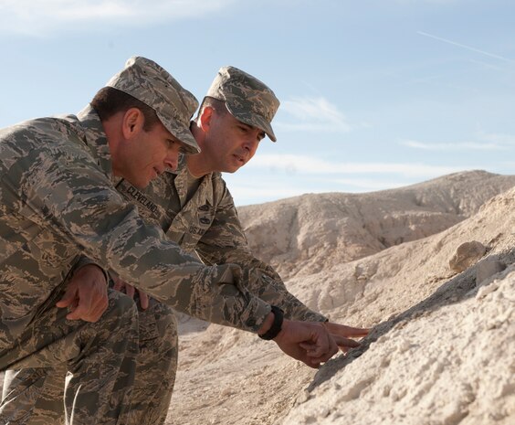 Col. Barry Cornish, 99th Air Base Wing commander, and Chief Master Sgt. Steven Cleveland, 99th ABW command chief, inspect the fossil remains of a mammoth Nov. 18, 2013, during a tour of Tule Springs fossil bed, Las Vegas. Cornish and Cleveland, along with other 99th ABW leaders, met with local scholars and members of the media to raise awareness of a bill that would protect the fossil beds as a national monument. (U.S. Air Force photo by Airman 1st Class Joshua Kleinholz)