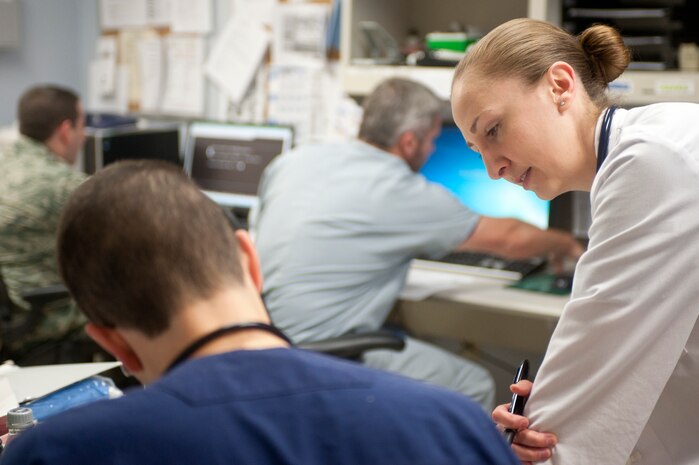 U.S. Air Force Capt. (Dr.) Merima White, 99th Medical Operations Squadron Family Medicine Residency resident physician, discusses symptoms of a patient at the Mike O’Callaghan Federal Medical Center Nov. 16, 2013. White grew up in Sarajevo, Bosnia-Herzegovina during the Bosnian Conflict as a child and moved to the U.S. in 1994. White studies and trains in the Family Medicine Residency Program that aims to provide world class instruction so graduate physicians can supply a personal medical home whether deployed or in garrison. (U.S. Air Force photo by Staff Sgt. Christopher Hubenthal)