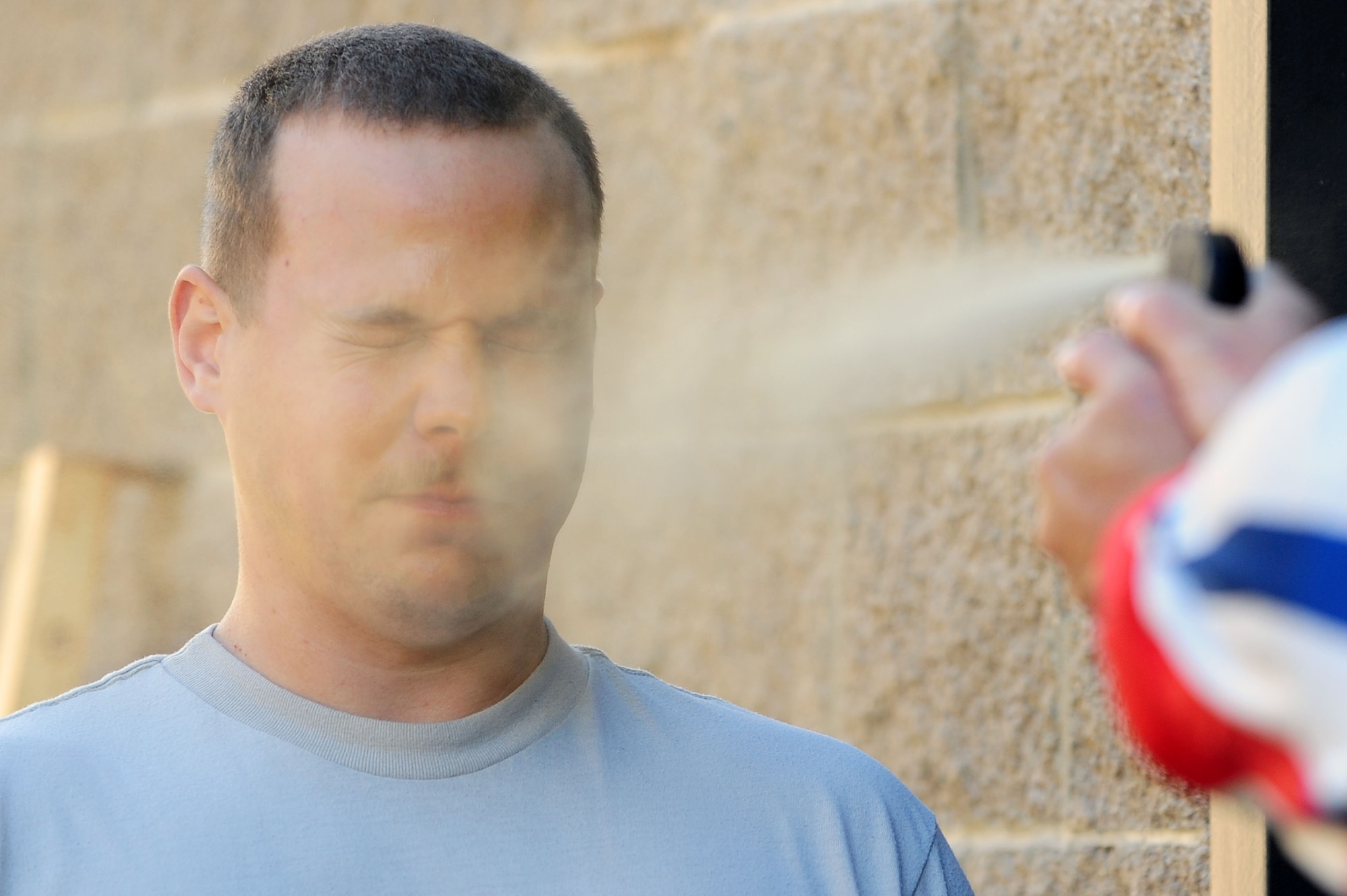 U.S. Air Force Airman 1st Class Aaron Jenne, 4th Fighter Wing public affairs photojournalist, is sprayed with oleoresin capsicum (OC) spray during a Security Forces Augmentee training class at Seymour Johnson Air Force Base, N.C., Nov. 8, 2013. OC spray is a non-lethal weapon that most law enforcement officials carry to use in non life-threatening situations. After being sprayed during training, Airmen earn a certification to carry OC spray when on duty as an SF Augmentee. (U.S. Air Force photo by Airman 1st Class John Nieves Camacho)
