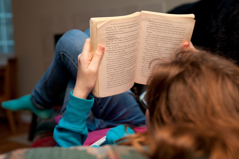 Paige Dandaneau, daughter of Master Sgt. Julie Dandaneau, 633rd Surgical Operations Squadron surgical services flight chief, reads a book in her home in Newport News, Va., Nov. 16, 2013. Dandaneau adopted Paige, 13, when she was 5 years old. (U.S. Air Force photo by Stephanie R. Plichta/Released)