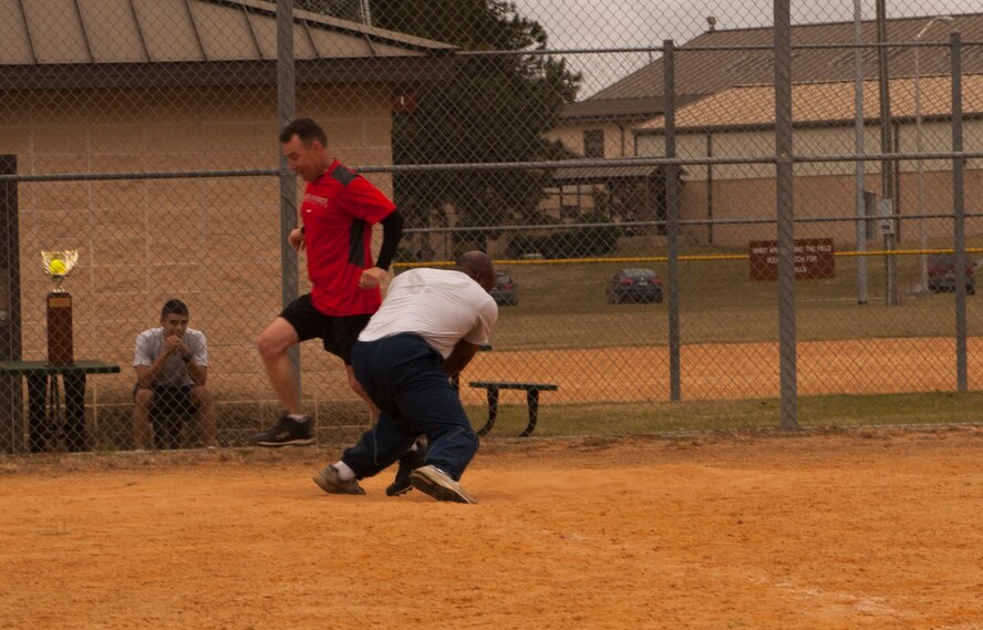 U.S. Air Force Col. Chad Franks, left, 23d Wing commander, avoids an attempted out by Chief Master Sgt. Brian Miller, 23d Mission Support Group chief enlisted manager, at Moody Air Force Base, Ga., Nov. 15, 2013. Franks scored the run for the Eagles during the annual Chiefs vs. Eagles softball game. (U.S. Air Force photo by Airman 1st Class Alexis Grotz/Released)