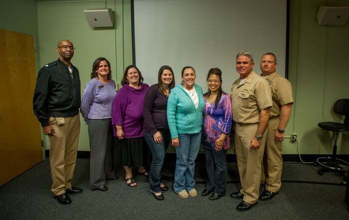 Joint Base Charleston leadership welcomed new certified Navy Ombudsman Nov. 15, 2013, at JB Charleston – Weapons Station, S.C. Pictured (right to left) is Cmdr. Marquis Patton, Navy Munitions Command Unit Charleston commanding officer, Anna Flowers, JB Charleston fleet and family center director, Beth Darius, Navy certified ombudsman trainer, Chelsea Crowell, jb Charleston Naval Support Activity Ombudsman, Rachel Gentry, U.S. Coast Guard Sector Charleston Ombudsman, Suerjee Lee, JB Charleston Ombudsman coordinator, Navy Capt. Tim Sparks, JB Charleston deputy commander, Master Chief Joseph Gardner, JB Charleston command master chief. Ombudsmen are here to assist Navy families. Ombudsmen act as a liaison between the command and families, and communicate information about command and community resources to families. (U.S. Air Force photo / Senior Airman Tom Brading)