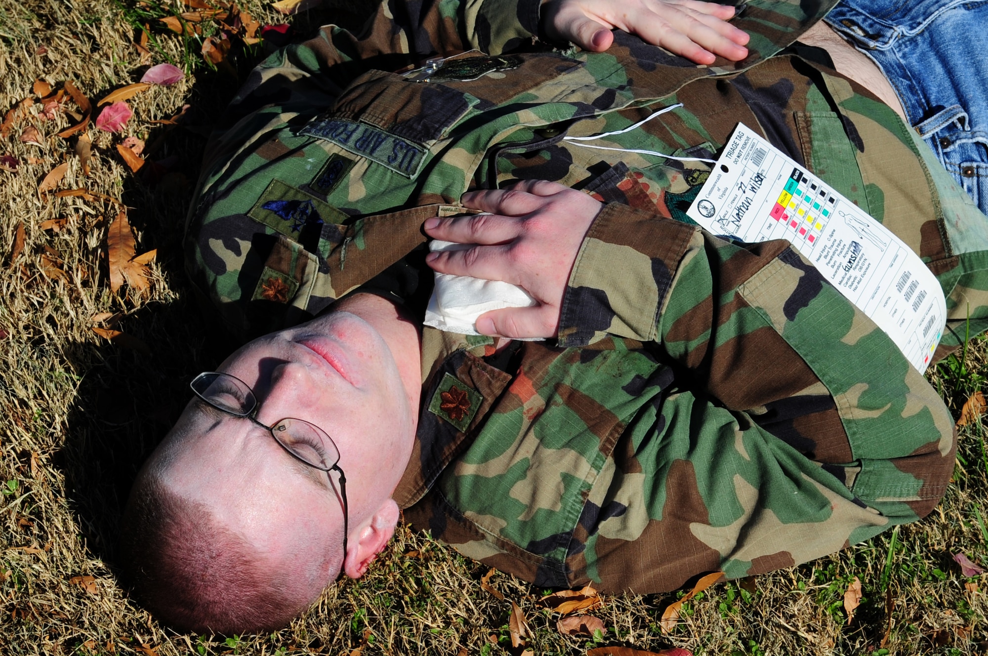 U.S. Air Force Airman 1st Class Nathan Wilson, 633rd Communications Squadron radio frequency transmission system technician, awaits medical attention during an active-shooter exercise at Langley Air Force Base Va., Nov. 19, 2013. In the simulated scenario, Wilson was shot after refusing to sell  a trailer to an Airman who recently returned from deployment. (U.S. Air Force photo by Airman Areca T. Wilson/Released)