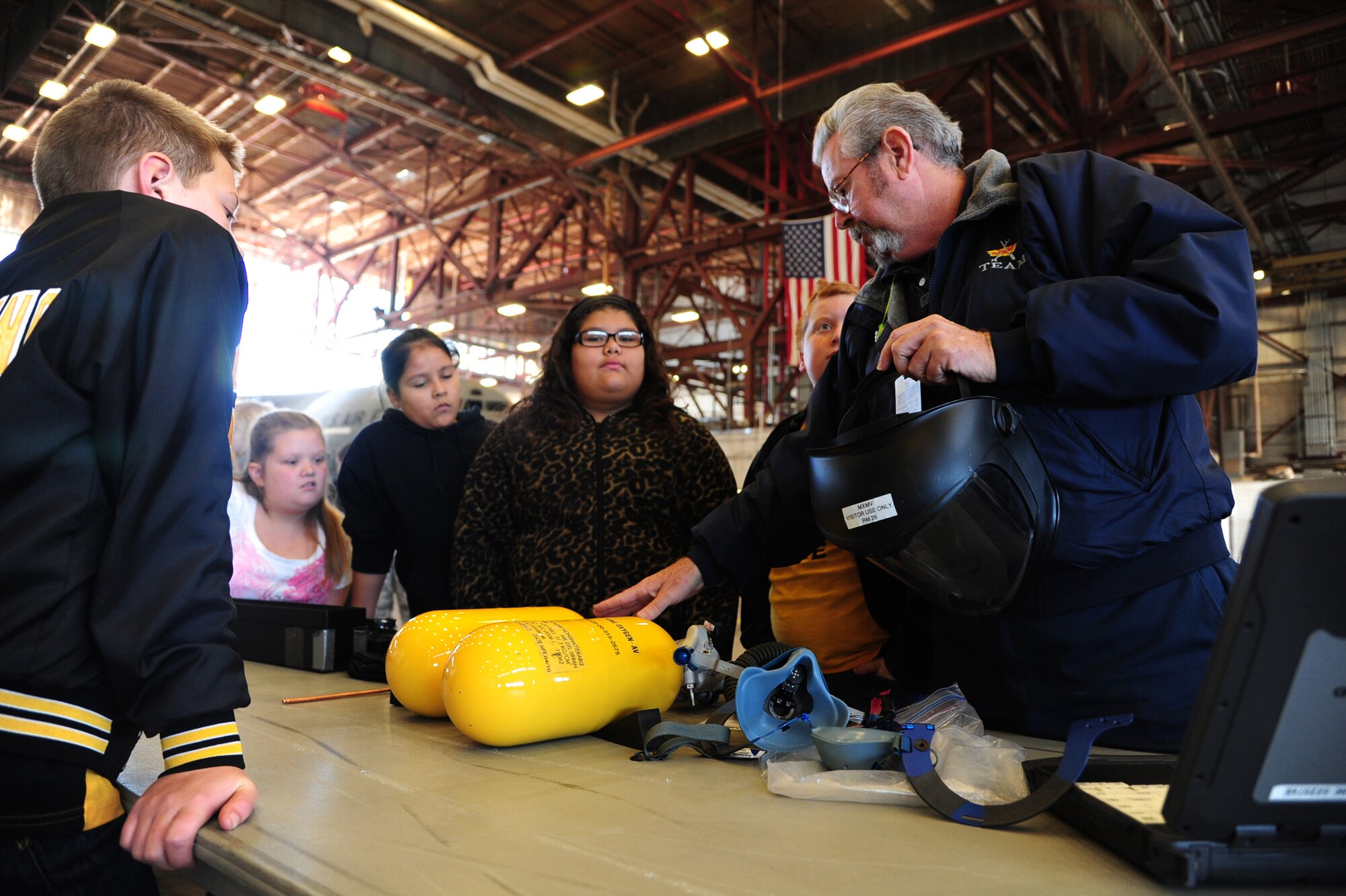 ALTUS AIR FORCE BASE, Okla. -- John Conway, 97th Maintenance Directorate electro environmentalist, shows fifth-grade students from Burns Flat equipment used to inspect oxygen bottles during the STARBASE Career Day Nov. 18, 2013. The day focused on showing the students how science, technology, engineering and math are applied to jobs in the military. The STARBASE program aims to motivate students to explore STEM as they continue their education. (U.S. Air Force photo by Senior Airman Lausanne Genuino/Released)