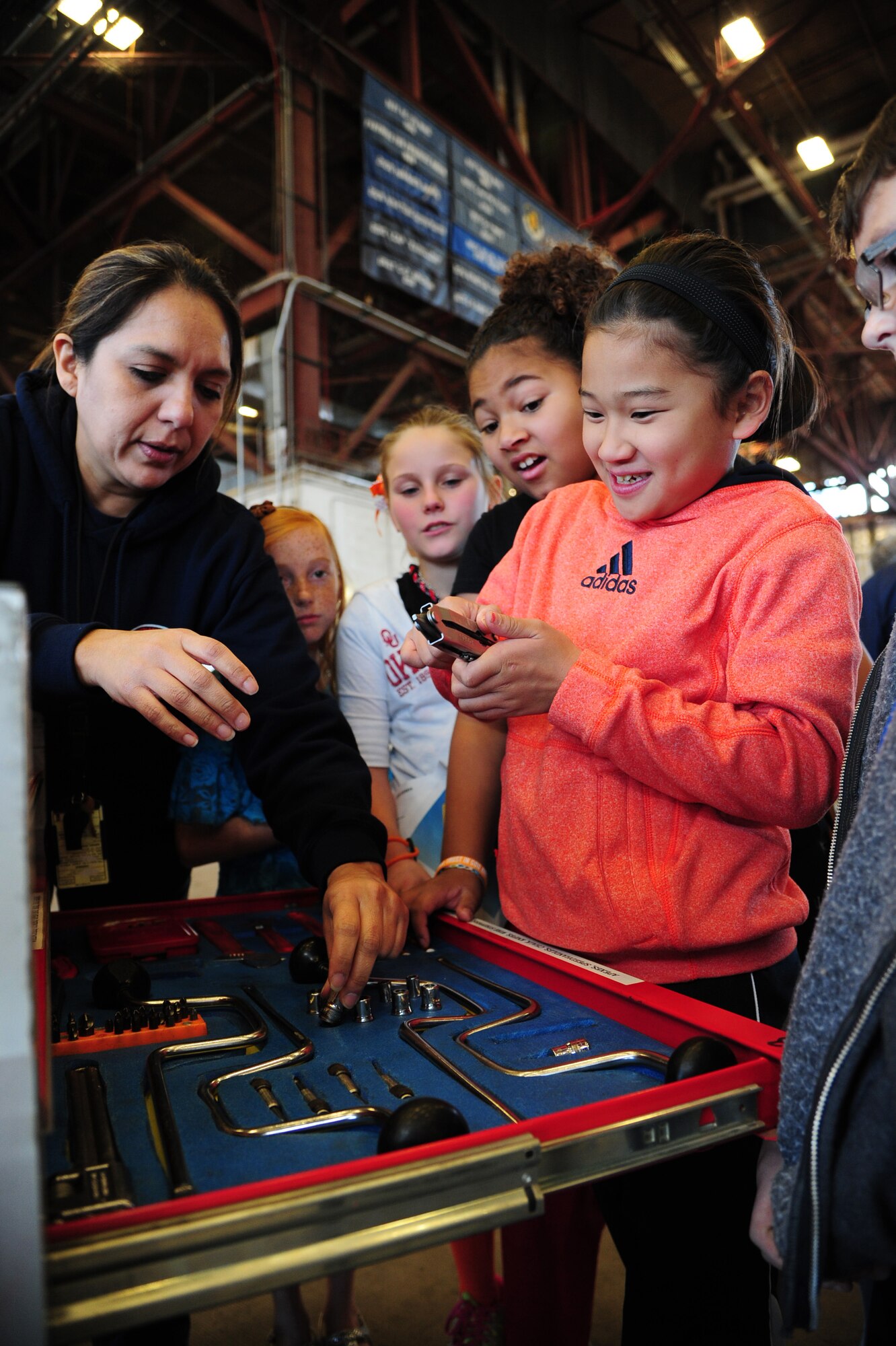 ALTUS AIR FORCE BASE, Okla. -- Joanna Adrian, 97th Maintenance Directorate aircraft mechanic, shows fifth-grade students tools used to maintain an aircraft during the Burns Flat STARBASE Career Day Nov. 18, 2013. Approximately 75 fifth-grade students visited various base agencies to see how science, technology, engineering and math are applied to jobs in the military. The STARBASE program aims to motivate students to explore STEM as they continue their education. (U.S. Air Force photo by Senior Airman Lausanne Genuino/Released)