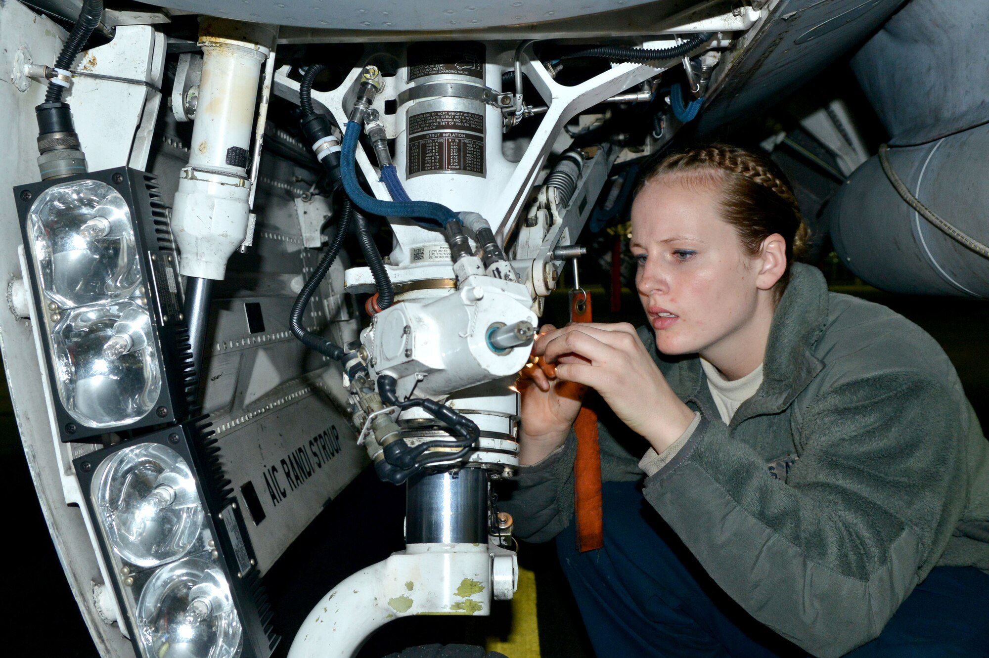U.S. Air Force Airman 1st Class Randi Stroup, 20th Aircraft Maintenance Squadron tactical aircraft maintainer, inspects the landing gear of a F-16 Fighting Falcons to make sure the aircraft is mission ready, Shaw Air Force Base, S.C., Nov. 17, 2013. To keep the F-16 Fighting Falcons in tip top shape, maintainers at Shaw endure long shifts during all types of weather. (U.S. Air Force photo by Airman 1st Class Ashley L. Gardner/Released)
