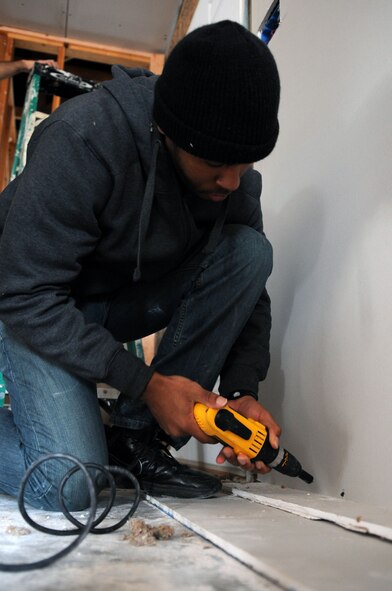 U.S. Air Force Senior Airman Brandonn Brown, 7th Operations Support Squadron, installs a piece of sheetrock Nov. 14, 2013, in Abilene, Texas. Brown, along with other Airmen from the 7th OSS, volunteered at a Habitat for Humanity worksite during a community service project. Habitat for Humanity is a non-profit Christian ministry that builds affordable homes for low-income families. (U.S. Air Force photo by Senior Airman Shannon Hall/Released)