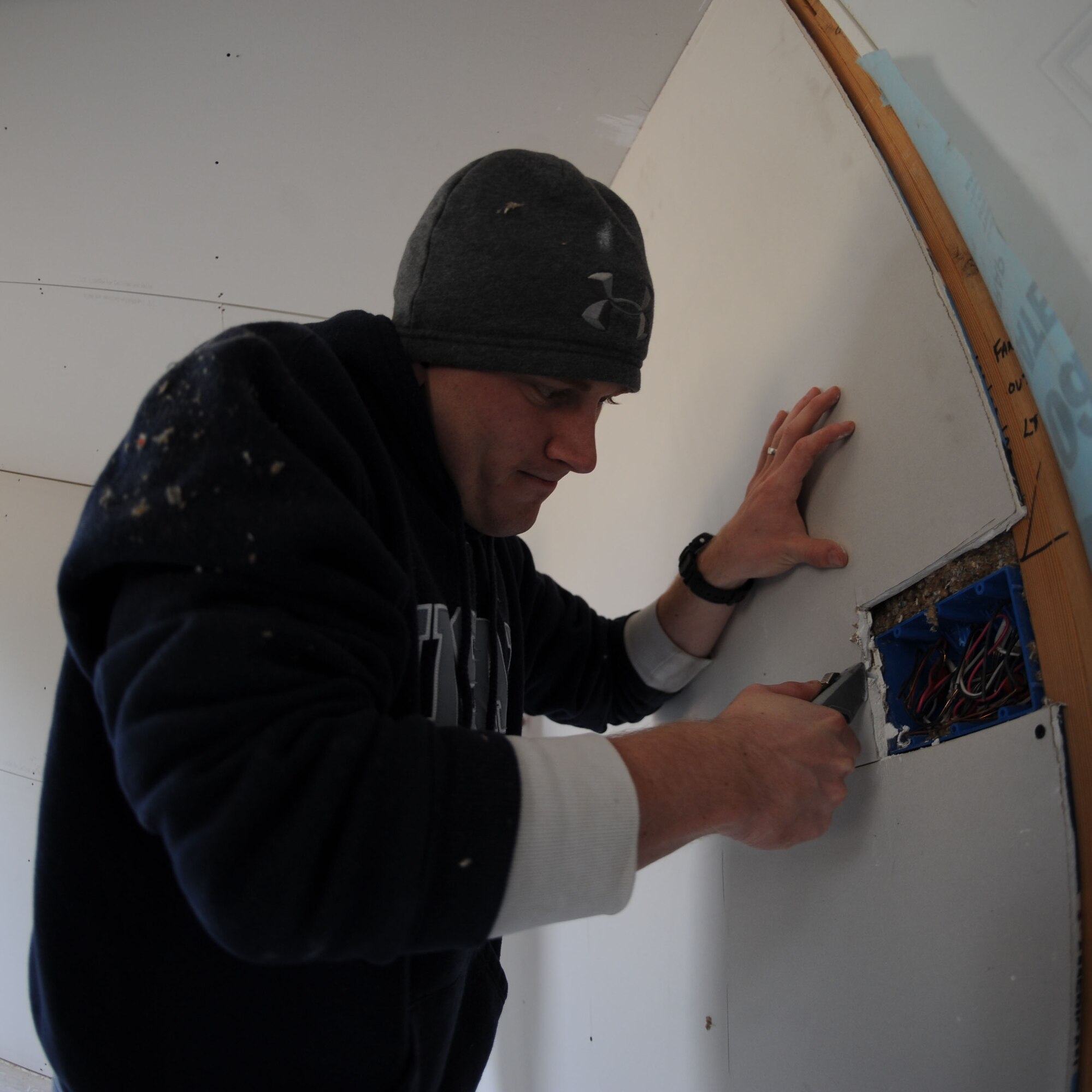 U.S. Air Force Airman 1st Class Casey Millikan, 7th Operations Support Squadron, trims a piece of sheetrock Nov. 14, 2013, in Abilene, Texas. Millikan, and over 30 other Airmen from the 7th OSS, worked split-shifts at an Abilene home hanging sheetrock. The squadron worked with Habitat for Humanity, a non-profit ministry organization that has helped build or repair more than 800,000 homes. (U.S. Air Force photo by Senior Airman Shannon Hall/Released)