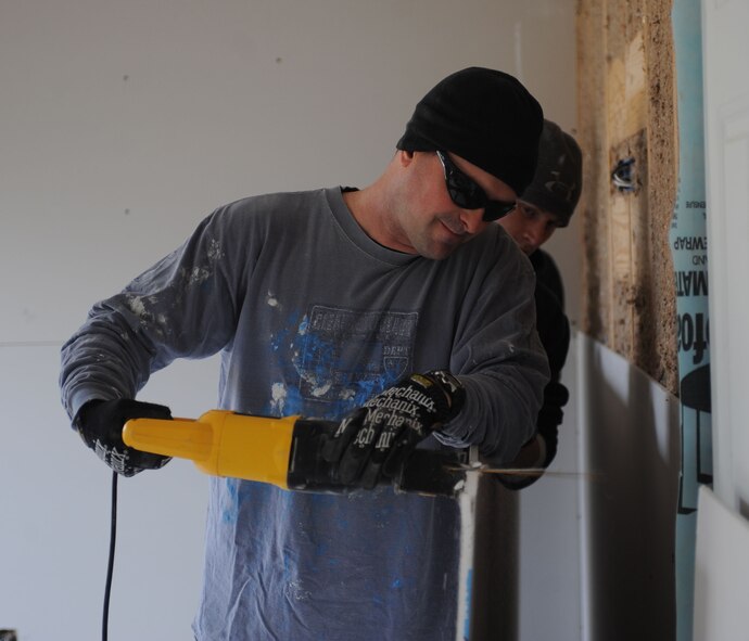 U.S. Air Force Lt. Col. Brian Golden, 7th Operations Support Squadron commander, saws a piece of sheetrock Nov. 14, 2013, in Abilene, Texas. Airmen from the 7th OSS spent time volunteering for Habitat for Humanity as one of their community service projects for their squadron. (U.S. Air Force photo by Senior Airman Shannon Hall/Released)