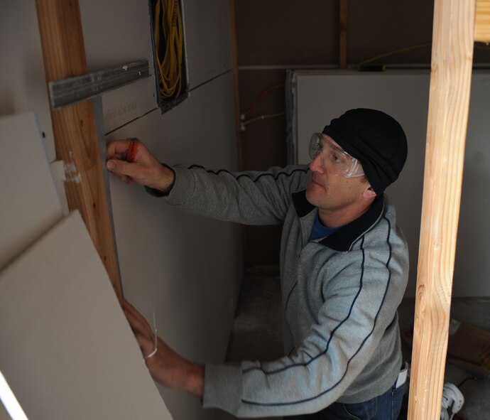 U.S. Air Force Maj. Brandon Miller, 7th Operations Support Squadron, measures a piece of sheetrock Nov. 14, 2013, in Abilene, Texas. Miller, along with other Airmen for the 7th OSS volunteered to put up sheetrock in an Abilene home for Habitat for Humanity. (U.S. Air Force photo by Senior Airman Shannon Hall/Released)
