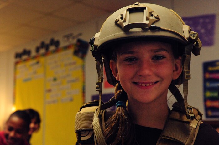 Fifth grade student Rachael Rodriguez tries on a combat helmet and vest during a demonstration given by Airmen Nov. 8, 2013 at Doris French Elementary in Las Vegas.  Throughout the day, 16 Airmen rotated through classrooms giving presentations about their career fields and answering questions about life in the military. (U.S. Air Force photo by Airman 1st Class Joshua Kleinholz)