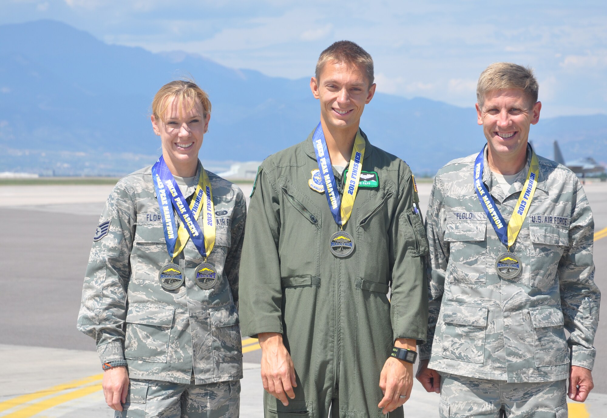 With Pikes Peak visible from the Peterson Air Force Base flightline, 302nd Airlift Wing members Staff Sgt. Denise Flory, Capt. Steven Paap and Lt. Col. Alan Flolo, display their marathon medals. Flory, 302nd Airlift Wing historian, Paap, a C-130 pilot with the 52nd Airlift Squadron and Flolo, commander of the 302nd Force Support Squadron were all finishers of the Aug. 19 Pikes Peak Marathon, which is rated the second most difficult marathon in the world. (U.S. Air Force photo/Ann Skarban)