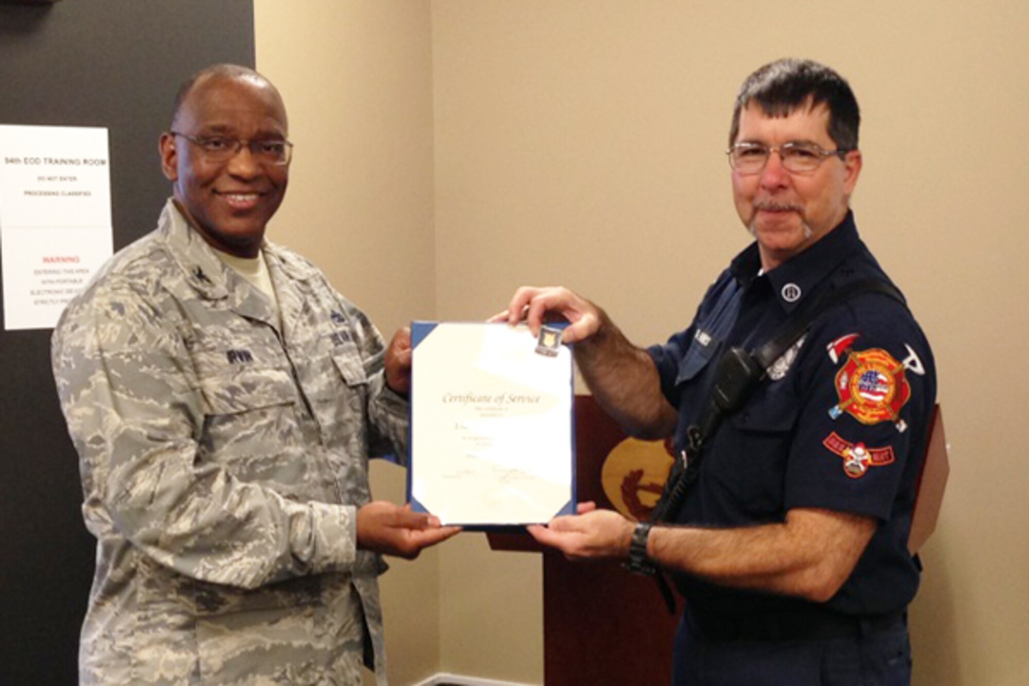 Col. Marshall Irvin, 94th Mission Support Group commander, presents Daniel Harris of the Dobbins Fire Department with a Certificate of Appreciation for 30 years of service to the federal government. “Thank you, Mr. Harris,” said Irvin. “We are proud to honor the dedication and sacrifice. Keep doing what you’re doing!” (U.S. Air Force photo/Brad Fallin) 