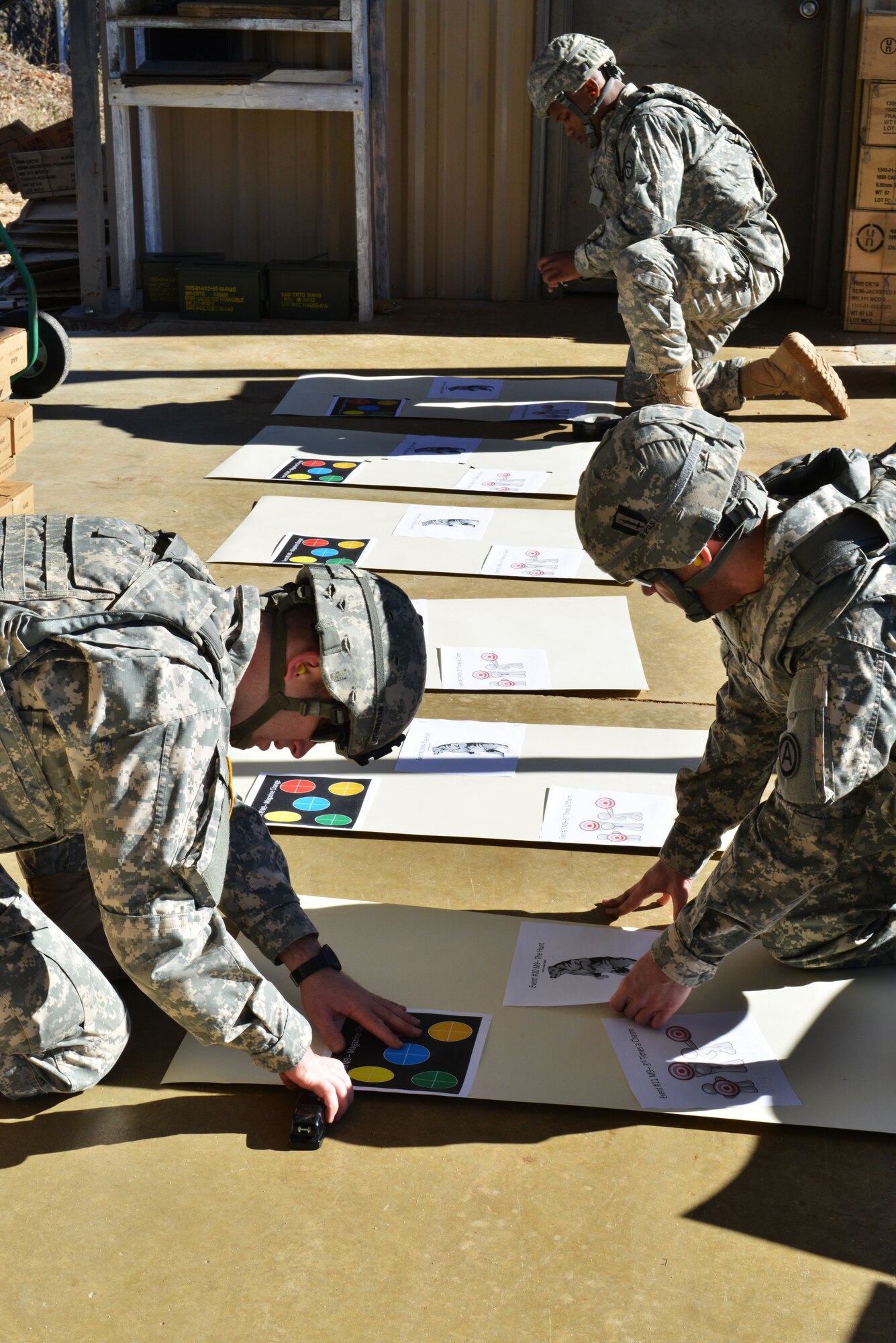 U.S. Army Soldiers prepare firing targets for a “top shot” marksmanship competition at the 20th Security Forces Squadron Combat Arms and Training Maintenance firing range, Shaw Air Force Base S.C., on Nov. 14, 2013. The three prepared 11 various targets that were used during the competition. (U.S. Air Force photo by Airman 1st Class Jensen Stidham/Released)