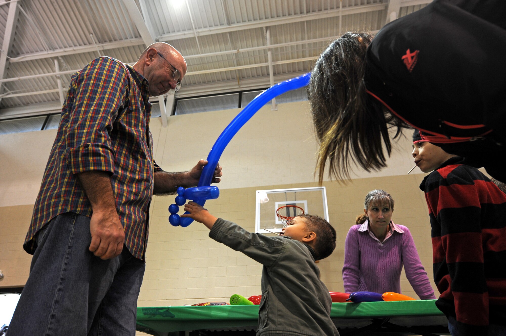U.S. Air Force Chief Master Sgt. Jeffrey Craver, 4th Fighter Wing command chief, hands a balloon sword to a member of Team Seymour during the Month of the Military Family block party at Seymour Johnson Air Force Base, N.C., Nov. 16, 2013. Craver and his wife, Kelley, volunteered to provide entertainment and honor military families during the event. (U.S. Air Force photo by Airman 1st Class Aaron J. Jenne)