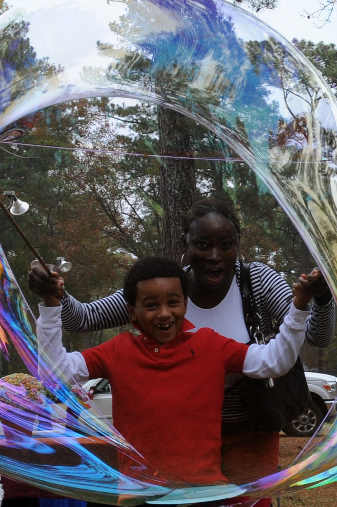 U.S. Air Force Tech. Sgt. Sara-Ann Richards, 4th Aircraft Maintenance Squadron knowledge operations manager, and her son create a large bubble during a Month of the Military Family event at Seymour Johnson Air Force Base, N.C., Nov. 16, 2013. Face painting, pony rides and a petting zoo were also featured. (U.S. Air Force photo by Airman 1st Class Aaron J. Jenne)