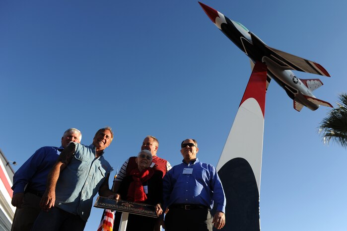 From left: Bill Devlin, Rick Dale, Mark Devlin, Shirley Buckley, and Bill Devlin. Buckley and her sons were the guests of honor at a ceremony Nov. 15, 2013, to dedicate an F-105 "Thunderchief" replica in front of the Thunderbirds hangar. Buckley's late husband, Capt. Gene Devlin, was killed in an F-105 accident in 1964, and the 39-year-old memorial display was recently reconditioned at "Rick's Restorations" in Las Vegas. (U.S. Air Force photo/Staff Sgt. Larry E. Reid Jr.)