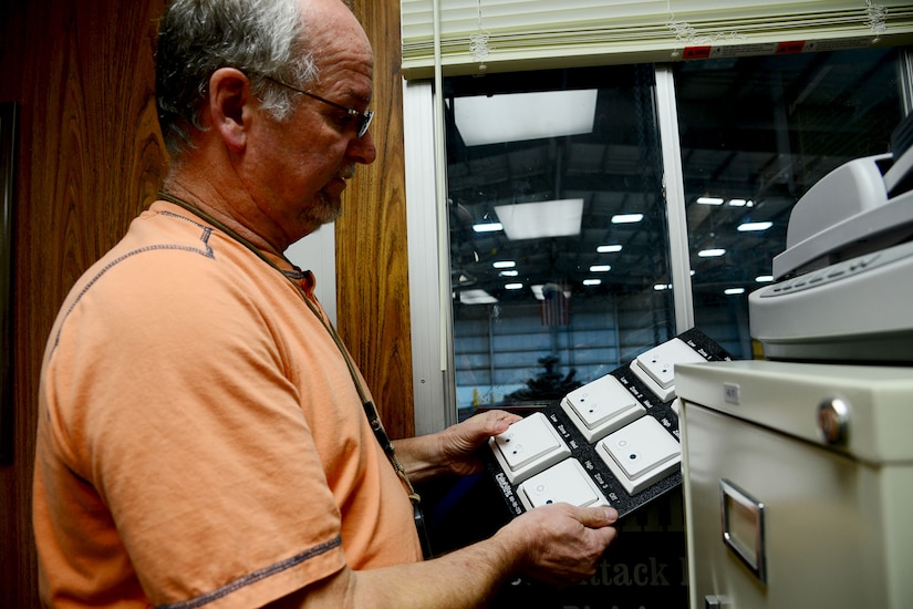 David Malpass, 733rd Civil Engineer Division assistant energy manager, demonstrates how T-5 lights are controlled by a battery-less, wireless control panel at Fort Eustis, Va., Nov. 18, 2013. The control panel turns off or dims lighting when not in use, saving energy and costs. (U.S. Air Force photo by Staff Sgt. Ashley Hawkins/Released)