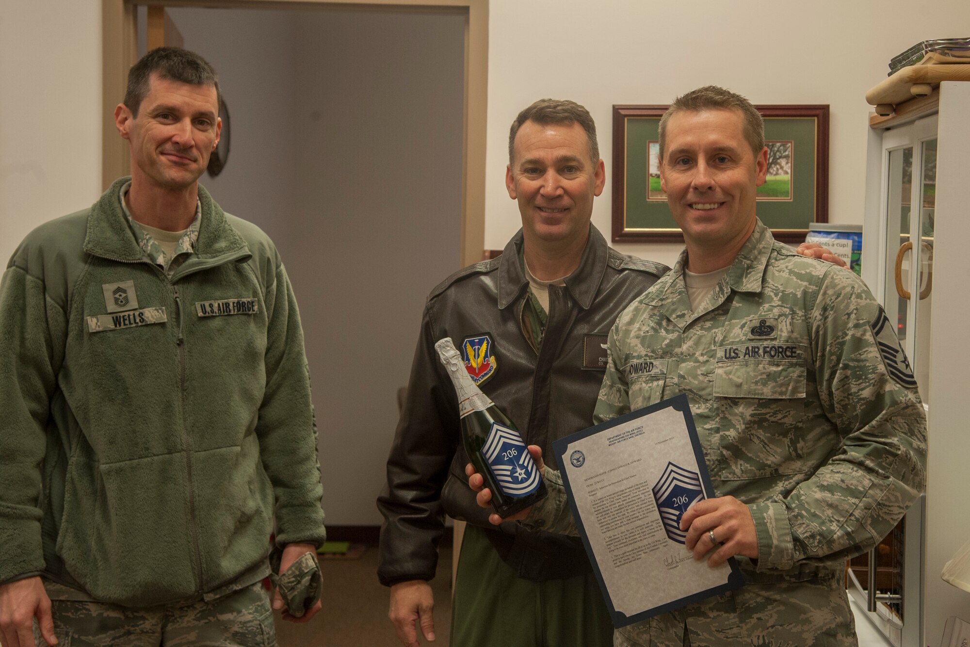 U.S. Air Force Chief Master Sgt. Matthew Wells, left, 23d Wing command chief, and Col. Chad Franks, center, 23d WG commander, announce to Senior Master Sgt. Donald Howard, 23d Force Support Squadron, that he was selected for promotion to chief master sergeant at Moody Air Force Base, Ga., Nov. 14, 2013. Franks, along with Maj. Gen. Jake Polumbo, Ninth Air Force commander, Chief Master Sgt. Scott Fuller, 9th AF command chief, and Moody group commanders and chiefs greeted the four new chief master sergeants. (U.S. Air Force photo by Airman Dillian Bamman/Released)