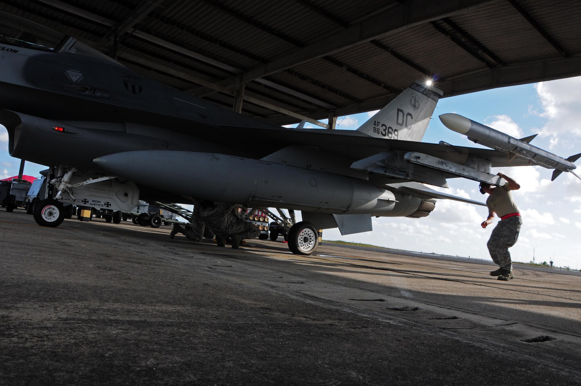 U.S. Air Force airmen from the 113th Maintenance Squadron perform an inspection of an F-16 prior to take off at Natal Air Base, Brazil, Nov. 12, 2013. The purpose of CRUZEX is to prepare participants to work effectively in support of multinational operations. (U.S. Air Force photo by Senior Airman Camilla Elizeu/Released)