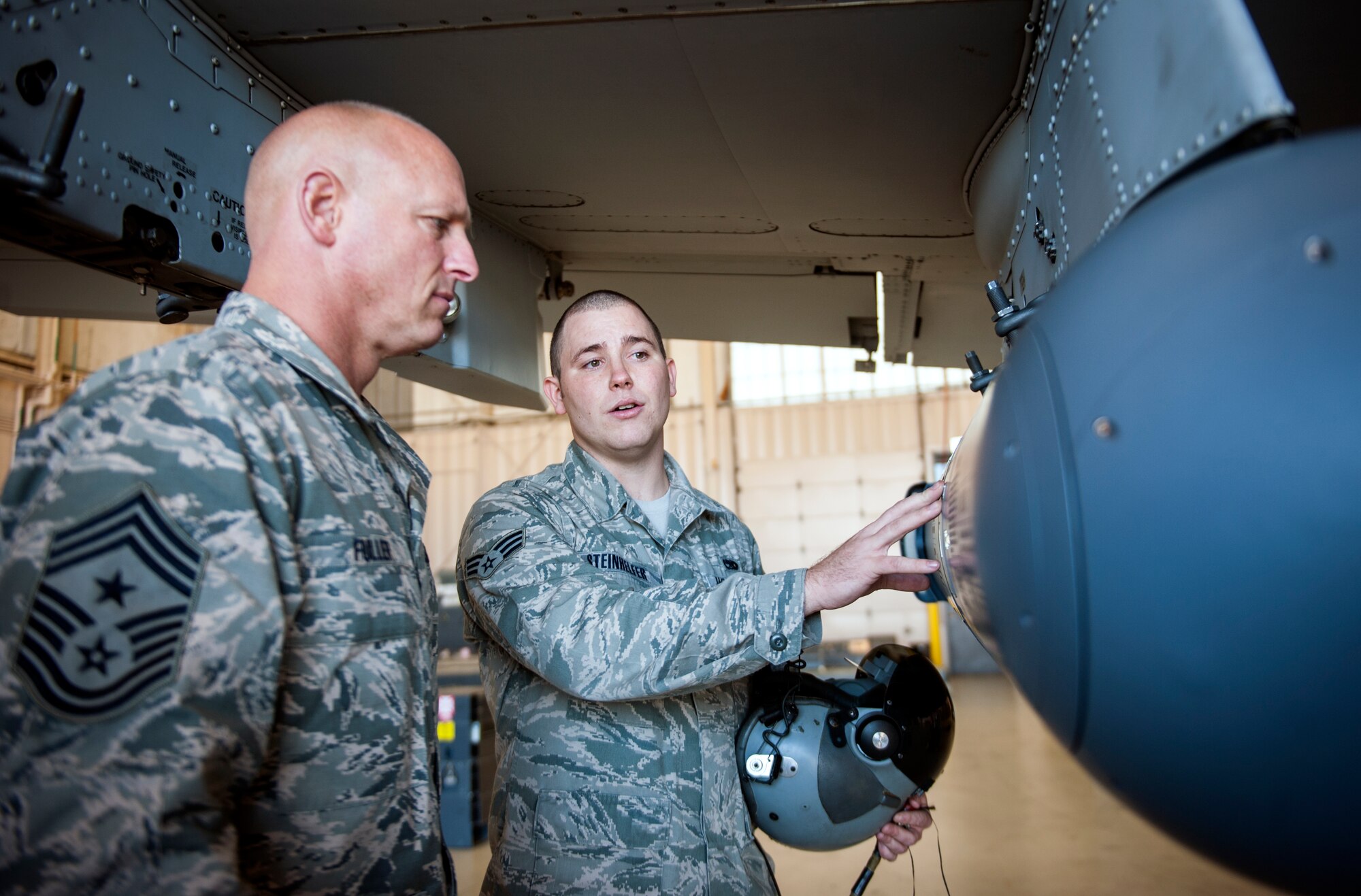 U.S. Air Force Senior Airman Ronald Steinhelfer, 23d Aircraft Maintenance Squadron avionics journeyman, talks to Chief Master Sgt. Scott Fuller, Ninth Air Force command chief, about the A-10C Thunderbolt II’s targeting pod at Moody Air Force Base, Ga., Nov. 13, 2013. During a visit by 9th AF leadership, Fuller conducted forums and unit visits while Maj. Gen. Jake Polumbo, 9th AF commander, participated in combat search and rescue training. (U.S. Air Force photo by Senior Airman Jarrod Grammel/Released)
