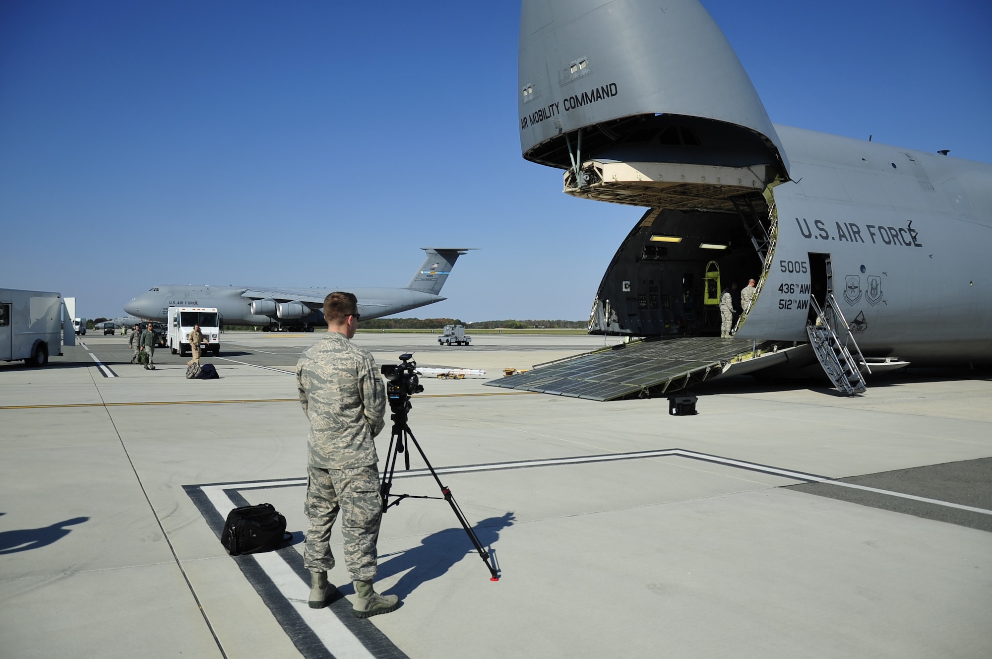 Airman 1st Class David Scott-Gaughan, 436th Airlift Wing Public Affairs video journalist, records a CH-47D Chinook helicopter being off loaded from a C-5M Super Galaxy Oct. 29, 2013, at Dover Air Force Base, Del. Scott-Gaughan was filming the unloading of the helicopter for training to further familiarize himself with his video equipment. (U.S. Air Force photo/Airman 1st Class William Johnson)