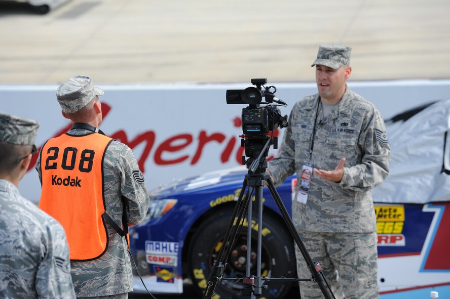 Tech. Sgt. Dale Gosney, 436th Airlift Wing Public Affairs NCO in charge of video operations, conducts an interview with an honorary pit crew member Sept. 27, 2013, at Dover International Speedway in Dover, Del. Gosney covered Team Dover’s support of Race Weekend. (U.S. Air Force photo/ Staff Sgt. Elizabeth Morris)