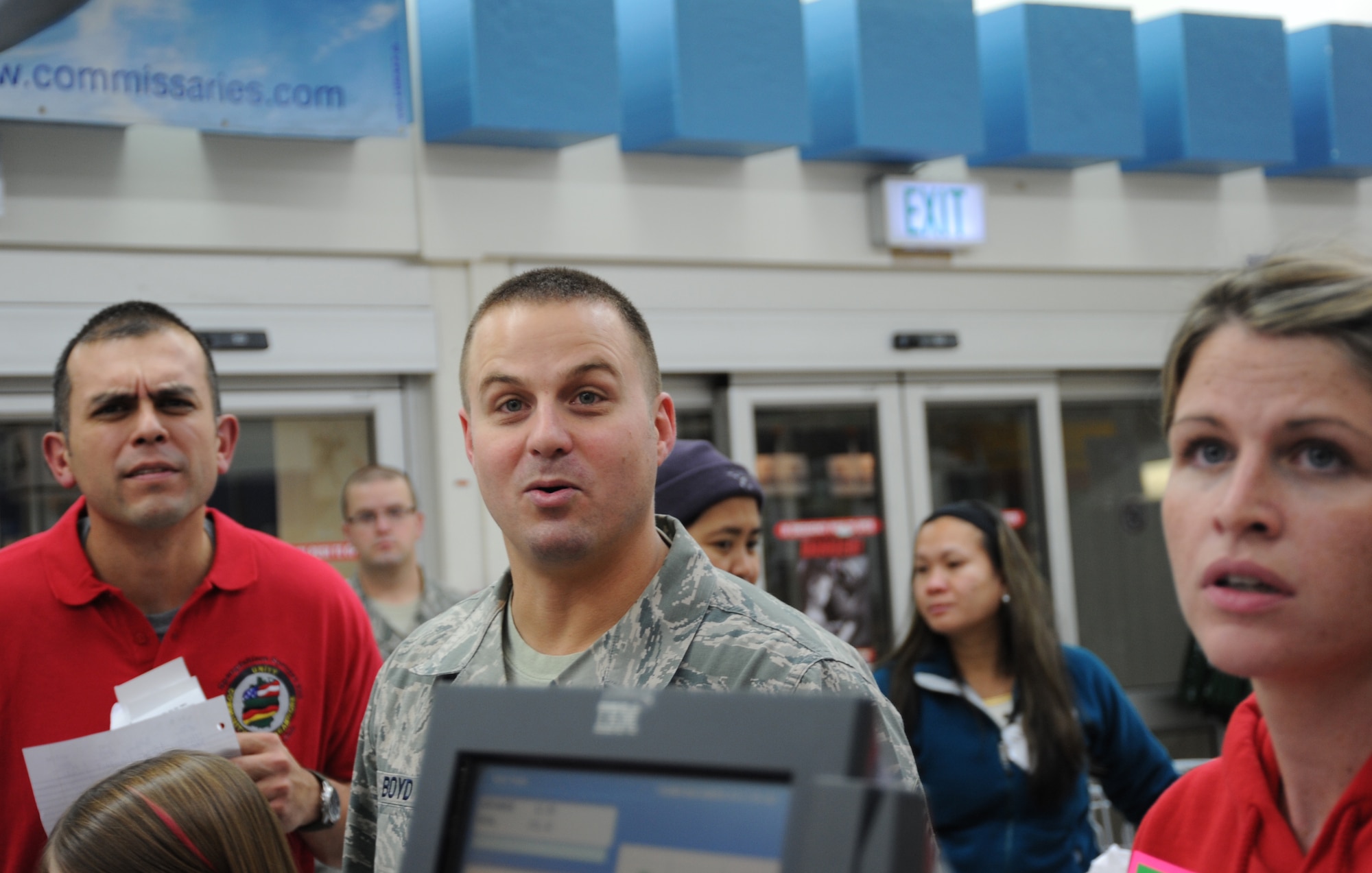 SPANGDAHLEM AIR BASE, Germany-- Tech. Sgt. Jaime Barajas, section chief of 52nd Component Squadron and event coordinator, left, Tech. Sgt. Jordan Boyd, assistant fire chief of 52nd Civil Engineer Squadron, center, and Emily Boyd, right, watch the total price of the Boyd's cart calculate on a screen during the Commissary Sweep Nov. 18, 2013, at the base commissary. The Commissary Sweep pitted four families against each other during the contest. (U.S. Air Force photo by Airman 1st Class Dylan Nuckolls/Released)
