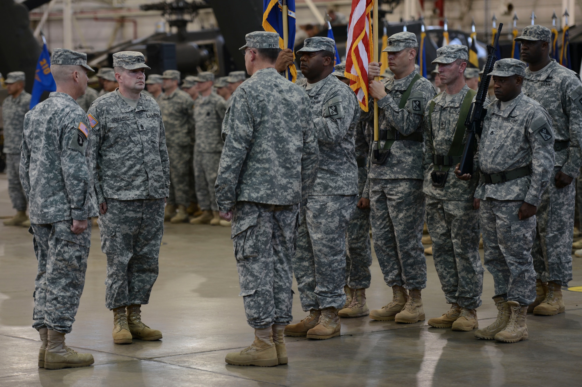 From left, U.S. Army Lt. Col. Richard Alexander, 1st Battalion, 210th Aviation Regiment commander, Sgt. Maj. Christopher Coolbaugh, incoming 1-210th Avn. Rgt. sergeant major, and Sgt. Maj. William L. Platt, outgoing 1-210th Avn. Rgt. sergeant major, wait for the passing of the colors during the 1-210th Avn. Rgt. change of responsibility ceremony at Fort Eustis, Va., Nov. 15, 2013. Coolbaugh most recently served as the strategic enlisted training developer for the 128th Avn. Brigade. (U.S. Air Force photo by Staff Sgt. Ciara Wymbs/Released)