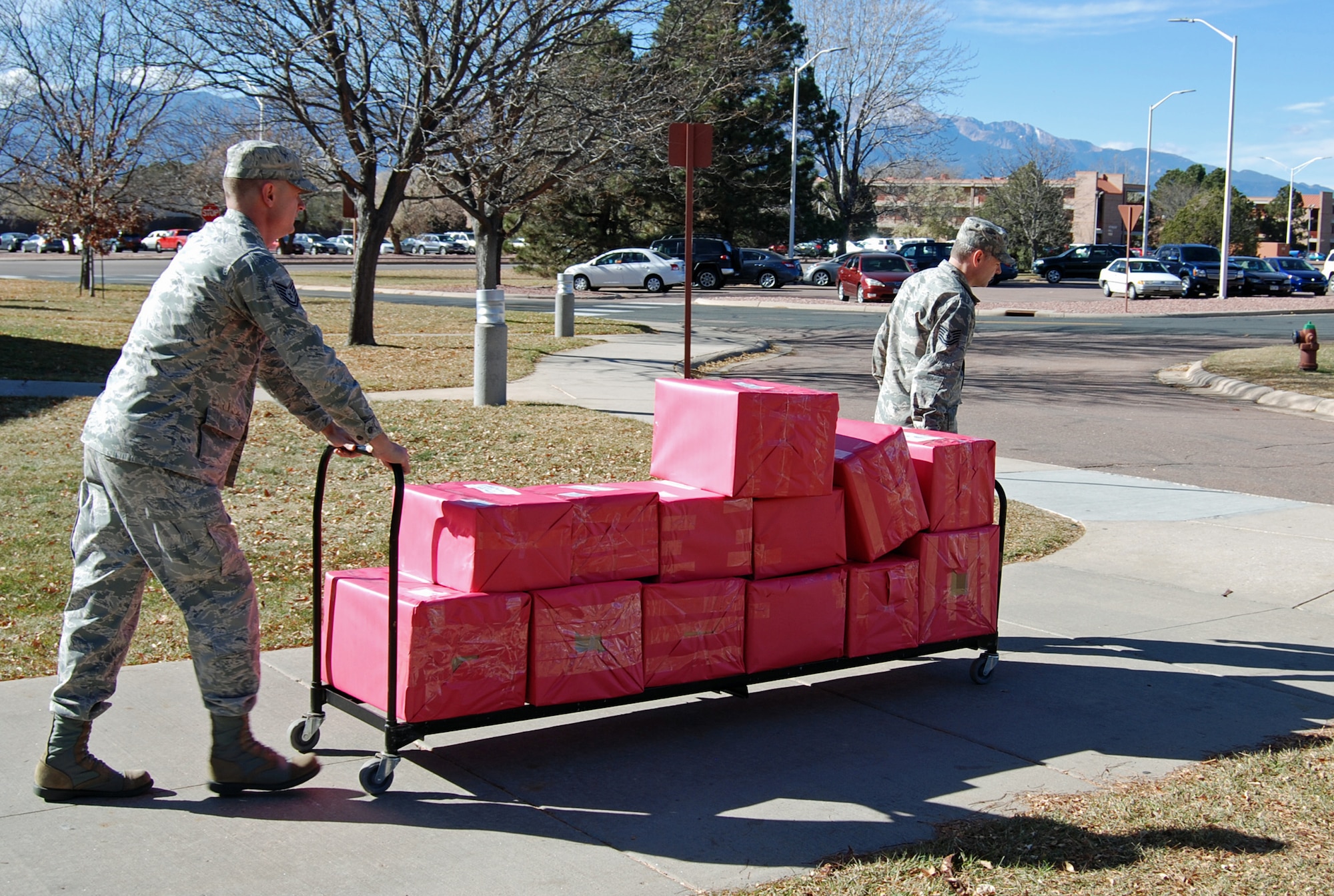 PETERSON AIR FORCE BASE, Colo. – Tech. Sgts. Scott Devine (left) and David Boice, 21st Space Wing chaplain assistants, load boxes of donated cookies gathered for deployed service members currently overseas. More than 40 bakers donated approximately 400 pounds of cookies that were mailed to deployed members at 13 locations throughout the Middle East. (U.S. Air Force photo/Michael Golembesky)