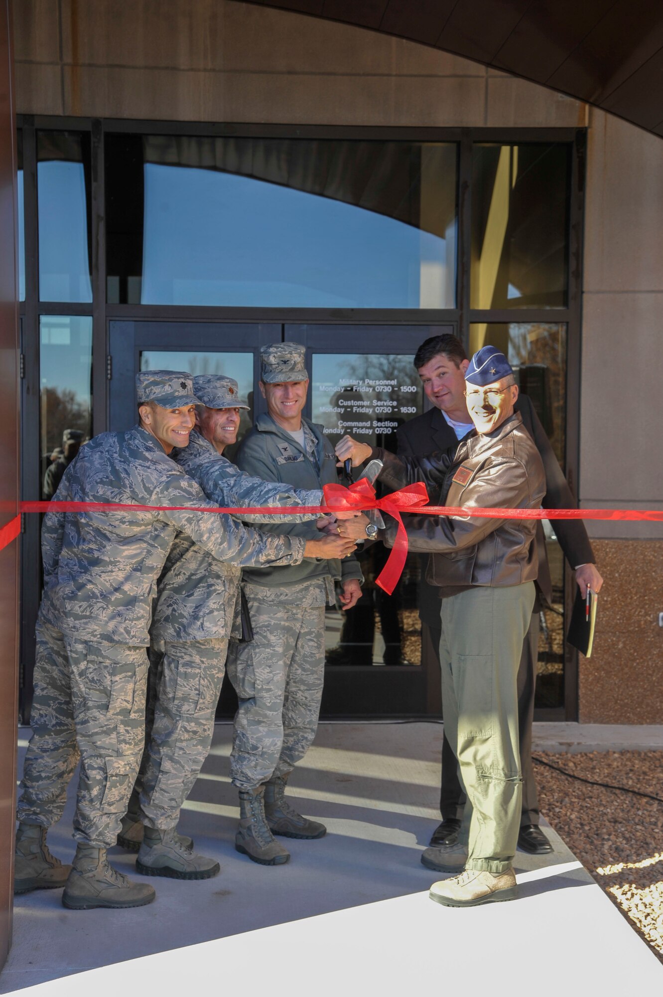 U.S. Air Force Brig. Gen.  Thomas Bussiere, 509th Bomb Wing commander, right; Gary Shirley, base architect; Col. Christopher Darling, 509th Mission Support Group commander; Maj. Chip Hollinger, 509th Force Support Squadron commander; and Lt. Col. Aaron Wilt, 509th Civil Engineer Squadron commander, cut the ribbon for the 509th FSS building’s grand opening at Whiteman Air Force Base, Mo., Nov. 13, 2013. The building is open from 7:30 a.m. to 3 p.m. (U.S. Air Force photo by Airman 1st Class Keenan Berry/Released)