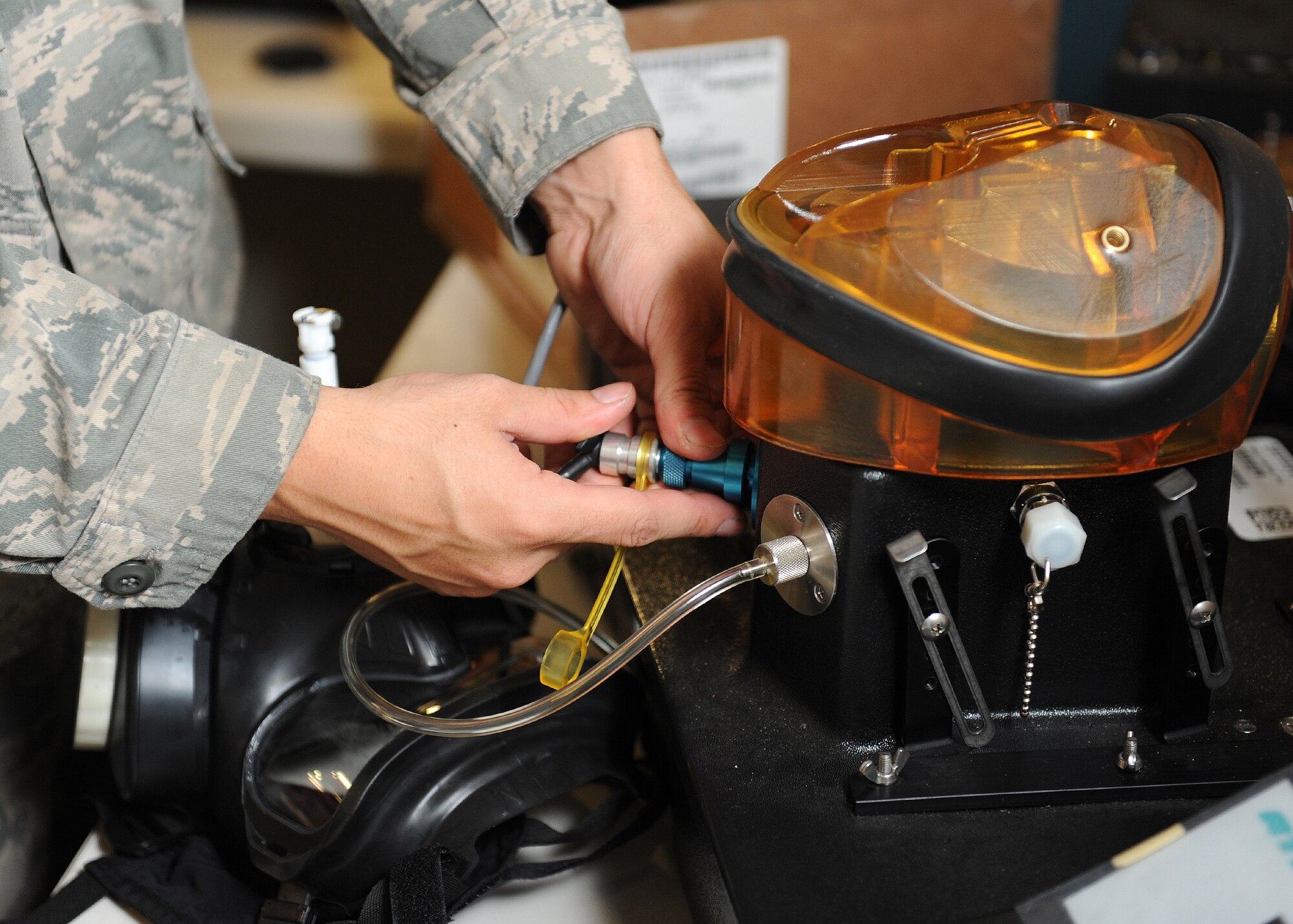 A valve on a gas mask tester is adjusted to check for air leaks in at the Deployment Control Center on Hurlburt Field, Fla., Oct. 31, 2013. A properly working gas mask protects Air Commandos against biological and chemical threats. (U.S. Air Force photo/Senior Airman Kentavist P. Brackin)