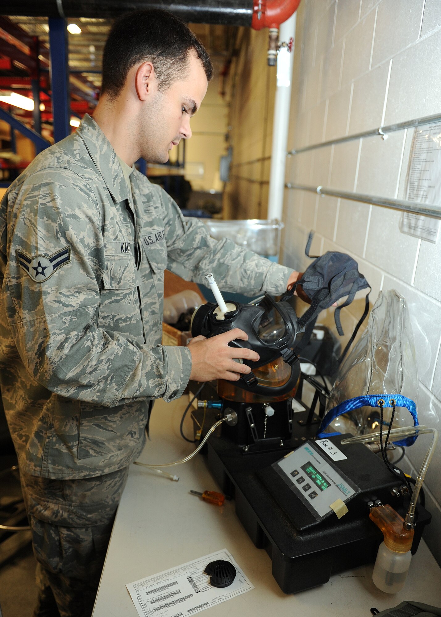 Airman 1st Class Andrew Kanter, 1st Special Operations Logistics Readiness Squadron supply clerk, places a gas mask on a gas mask tester at the Deployment Control Center on Hurlburt Field, Fla., Oct. 31, 2013. Ensuring gas masks are properly working is a vital component to the safety of deploying Air Commandos. (U.S. Air Force photo/Senior Airman Kentavist P. Brackin)