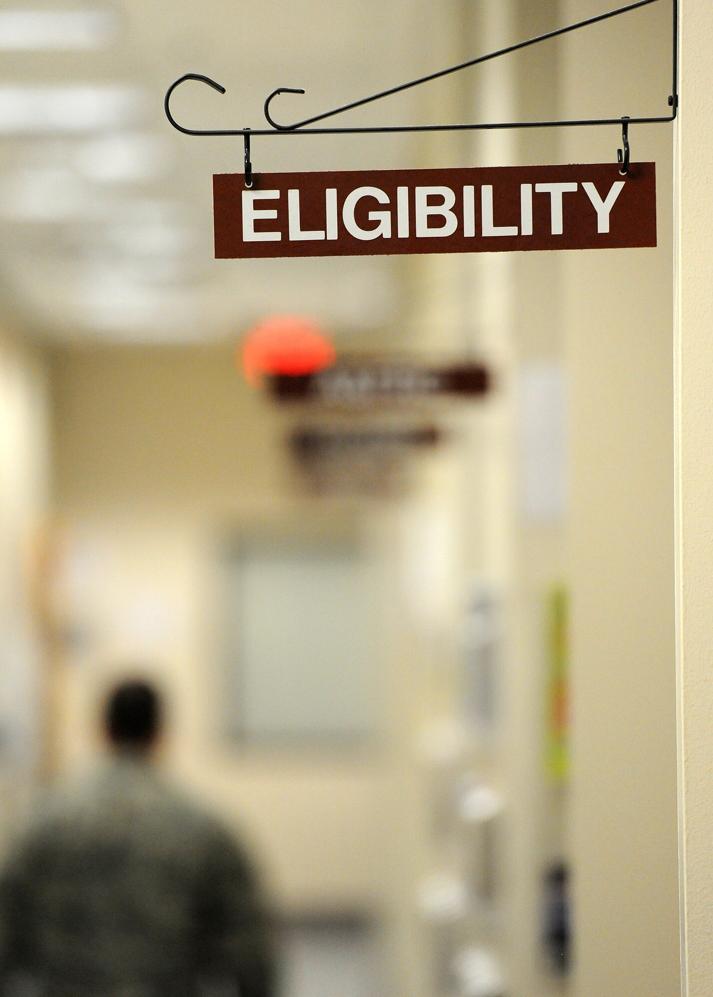 An Airman walks a hallway lined with various services available to ensure their readiness at the Deployment Control Center on Hurlburt Field, Fla., Oct. 31, 2013. Airman and Family Readiness, medical and legal services are offered at the center to ease the deployment process for Air Commandos and their families. (U.S. Air Force photo/Senior Airman Kentavist P. Brackin)